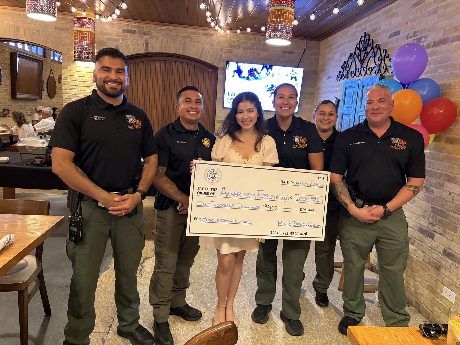 Scholarship recipient Anarissa Escamilla with South Explorers advisors holding her $1,000 award check